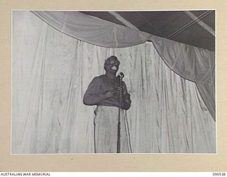 JACQUINOT BAY, NEW BRITAIN. 1945-04-15. SAPPER A. J. DONAHUE GIVING A RENDITION OF AL JOLSON'S "SUNNY BOY". HE IS PART OF A CONCERT PARTY, FORMED BY MEMBERS OF 33 DOCKS OPERATING COMPANY, ROYAL ..
