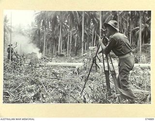 MILILAT, NEW GUINEA. 1944-07-22. NX108260 BOMBARDIER F.K. CONNOLLY (1) AND NX108256 SERGEANT J.B. LILLYMAN (2) OF THE 5TH SURVEY BATTERY, LEVELLING WITH A LONG WIRE AND A THEODOLITE ON THE MILILAT ..