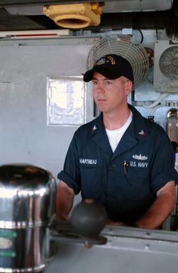 US Navy (USN) Quarter MASTER Second Class (QM2) Greg Martineau stands at the helm of USN Amphibious Command Ship USS BLUE RIDGE (LCC 19). The BLUE RIDGE is here to participate in Exercise TANDEM THRUST 2003