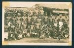 Group portrait of mess-gang standing outside the old mess house, Dormi is sitting front row fourth from right with x marked below him, [Bulolo Gold Dredging Ltd., Bulolo?], New Guinea, c1929 to 1932