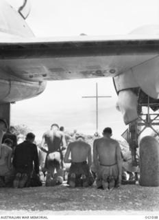 KIRIWINA, TROBRIAND ISLANDS, PAPUA. C. 1944-04. SERVICING CREWS OF NO. 30 (BEAUFIGHTER) SQUADRON RAAF AT EASTER SUNDAY CHURCH SERVICE CONDUCTED BY WILLIAM HARDY. THE AIRMEN ARE IN FRONT OF THE WING ..