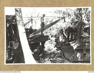 HUON PENINSULA AREA, NEW GUINEA. 1944-01-08. PERSONNEL OF THE 209TH LIGHT AID DETACHMENT REMOVING A GEARBOX FROM A MATILDA TANK WITH THEIR MOBILE CRANE IN THE UNIT WORKSHOP AREA ON THE BANK OF THE ..