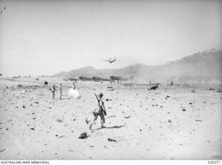 PAPUA. 1942-08-18. VIEW OF SEVEN MILE AERODROME NEAR PORT MORESBY AFTER A RAID BY 24 JAPANESE BOMBERS. THE CASUALTIES WERE ONE KILLED AND THIRTEEN INJURED; FOUR PLANES WERE DESTROYED AND SEVERAL ..