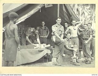 MILILAT, NEW GUINEA. 1944-08-09. NX77382 CAPTAIN R.B. BLACKETT, MEDICAL OFFICER (1) CONDUCTING AN EXAMINATION OF A PATIENT DURING THE MORNING SICK PARADE AT HEADQUARTERS, 5TH DIVISION. IDENTIFIED ..