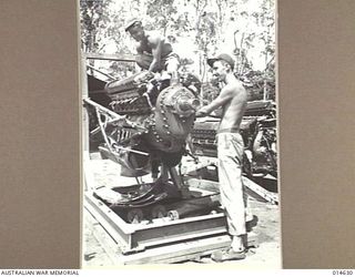 1943-04-12. NEW GUINEA. CPL. R.T. BARBER OF MONTANA AND SGT. R. F. ANDERSON OF FLINT, MICHIGAN REPAIRING MOTORS FOR P38 FIGHTERS IN NEW GUINEA. (NEGATIVE BY N. BROWN)