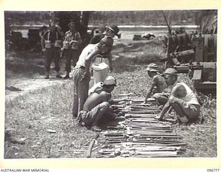 BUKA ISLAND, BOUGAINVILLE AREA, 1945-09-19. JAPANESE NAVAL TROOPS LISTING AND PLACING NAME TAGS ON THE SWORDS OF JAPANESE OFFICERS IN PREPARATION FOR THEIR COLLECTION BY AUSTRALIAN SURRENDER PARTY ..