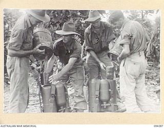 KARAWOP, NEW GUINEA. 1945-07-19. STUDENTS OF 2/6 CAVALRY (COMMANDO) REGIMENT LOADING THICK FUEL INTO A FLAME-THROWER TANK DURING THEIR ACTIVITIES AT THE FLAME-THROWER SCHOOL. THE FUEL IS IN THE ..