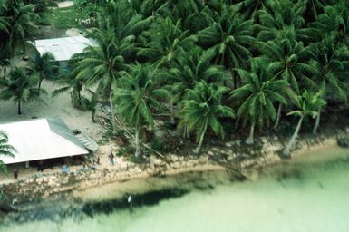 A view of buildings on a Micronesian island as seen from the back of a 374th Tactical Airlift Wing C-130 Hercules aircraft. The plane will be airdropping containers onto the island during Christmas Drop, an annual, humanitarian airdrop providing aid to needy islanders throughout Micronesia during the holiday season