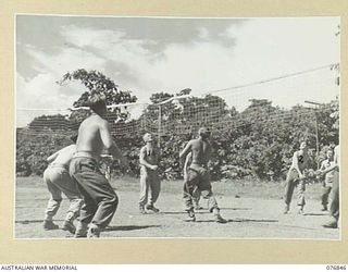 LAE, NEW GUINEA. 1944-11-11. SERGEANT F. DUNN, PHYSICAL TRAINING INSTRUCTOR, SUPERVISING A GAME OF VOLLEYBALL AMONG THE PATIENTS OF THE 112TH CONVALESCENT DEPOT