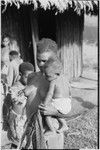 Wanuma: woman holds infant and young cassowary at Lutheran mission