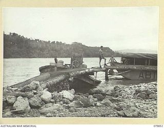 KAMANDRAN, NEW BRITAIN. 1945-03-16. A SUNKEN JAPANESE BARGE CONVERTED BY THE 1ST WATER AMBULANCE CONVOY, ROYAL AUSTRALIAN ENGINEERS, TO SUPPORT A JETTY USED BY THE HOSPITAL BARGE AB1078 TO EVACUATE ..