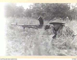 LAE, NEW GUINEA. 1944-09-13. SX1449 LIEUTENANT-COLONEL L.D. MEILL, COMMANDING OFFICER, 19TH INFANTRY BATTALION, TESTING THE MODIFIED BREN GUN. AMONG THE MODIFICATIONS MADE TO THE GUN WAS A ..