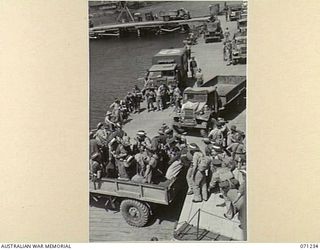 MILNE BAY, PAPUA, 1944-03-04. TROOPS FROM TOWNSVILLE, QUEENSLAND DISEMBARKING INTO TRUCKS AT LYAL WHARF