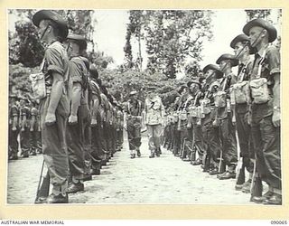 TOROKINA, BOUGAINVILLE. 1945-03-30. LORD WAKEHURST, GOVERNOR OF NEW SOUTH WALES (2), ACCOMPANIED BY MAJOR W. MCCALL, GUARD COMMANDER, 57/60 INFANTRY BATTALION (2), INSPECTING A GUARD OF HONOUR AT ..