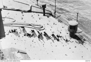 MILNE BAY. C.1943-04-14. DAMAGE TO THE DECK PLANKING ON THE STARBOARD SIDE OF THE FORECASTLE OF THE CORVETTE HMAS PIRIE. IT WAS CAUSED BY CANNON FIRE FROM A JAPANESE AIRCRAFT WHICH ATTACKED THE ..