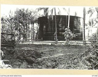 MILNE BAY, PAPUA, NEW GUINEA. 1944-04-03. A BULLDOZER PUSHING SOIL TO FORM A 'BUND', A PROTECTIVE WALL IN CASE OF LEAKAGE, AROUND A 500,000 GALLON OIL TANK AT THE 2ND BULK PETROLEUM STORAGE COMPANY