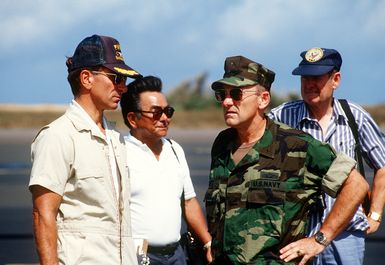 Military and civilian officials discuss damage to the Pacific Missile Range Facility (PMRF), Kauai, in the aftermath of Hurricane Iniki. Pictured, from left, are: CAPT. Robert Mullens, commanding officer, PMRF; John Mihara, Naval Facilities Engineering Command, Pacific Division; Rear Adm. (lower half) William Retz, commander, Naval Base, Pearl Harbor, and an unidentified official from the Federal Emergency Management Agency