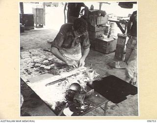 KARAWOP, NEW GUINEA, 1945-09-18. TPR R.J. PRIOR, COOK AT 2/6 CAVALRY COMMANDO REGIMENT, PREPARING A TASTY DISH