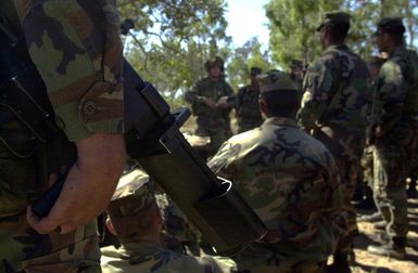 Holding an AT-4 Rocket Launcher (in foreground), Marines from India Company, 3rd Battalion, 3rd Marines weapon platoon, Kaneohe Bay, Hawaii, receive a range safety brief on during Exercise TANDEM THRUST. India Company is conducting a live fire range exercise consisting of firing AT-4 Rocket Launchers, Shoulder Mounted Anti Armor Weapons, and M-2O3 Grenade Launchers at the Shoalwater Bay Training Area. TANDEM THRUST is a biennial combined United States and Australian military training exercise, held in the vicinity of Shoalwater Bay Training Area in Queensland, Australia. More than 27,000 Soldiers, Sailors, Airmen and Marines are participating, with Canadian units taking part as opposing...