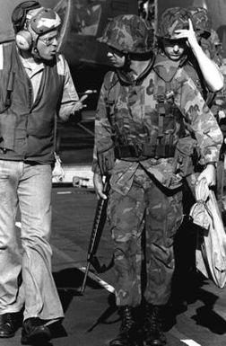 A flight deck crewman talks to a Marine who is preparing to board a helicopter for transfer from the amphibious assault ship USS GUAM (LPH-9), to Beirut, Lebanon, for duty as a member of a multinational peacekeeping force