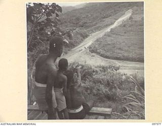 MAPRIK, NEW GUINEA. 1945-10-03. NATIVES AT AUSTRALIAN NEW GUINEA ADMINISTRATIVE UNIT HEADQUARTERS KEEPING A LOOKOUT FOR THE FOOD TRAIN