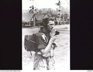 RABAUL, NEW BRITAIN, 1945-12-06. A SIGNALLER DEMONSTRATING A WIRELESS SET 108 IN ITS CARRIED POSITION DURING A DEMONSTRATION OF VARIOUS INFANTRY WEAPONS AND EQUIPMENT