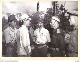 KAHILI, BOUGAINVILLE. 1945-09-20. MAJOR F.C. TAYLOR, BUIN LIAISON PARTY FROM HQ 2 CORPS, DISCUSSING THE DAY'S REQUIREMENTS WITH COMMANDANT IKIGAMI, JAPANESE NAVAL COMMANDER