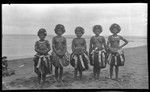 Motu women holding books; some are wearing kina, a crescent shell valuable necklace