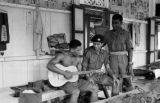 Malaysia, Republic of Fiji Military Forces soldiers watching man play guitar