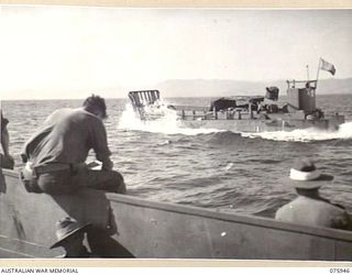 HANSA BAY AREA, NEW GUINEA. 1944-09-07. AUSTRALIAN ARMY BARGES LOADED WITH JAPANESE SALVAGE (DRUMS OF FUEL, TYRES ETC.) ON THE REGULATION RUN BETWEEN HANSA BAY AND MADANG