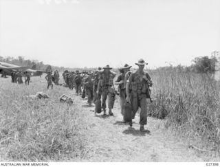 WANIGELA, NEW GUINEA. 1942-10. MEMBERS OF THE 2/6TH AUSTRALIAN INDEPENDENT COMPANY WHO HAVE JUST ARRIVED BY PLANE FROM PORT MORESBY CAME OUT OF THE PLANES READY EQUIPPED AND ARE SEEN HERE HEADING ..