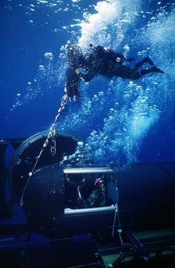 A Mark 8 special dive vehicle (SDV) is secured onto the drydock shelter (DDS) cradle on board the nuclear-powered submarine USS KAMEHAMEHA (SSN-642) as the deck captain deflates the DS-2 buoy during duel shelter special operations training off the coast of Oahu, Hawaii