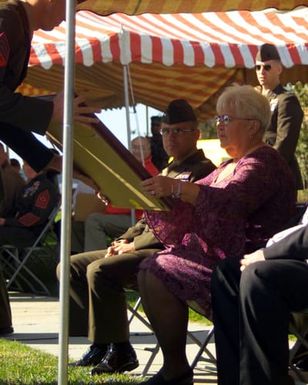 Mrs. Joan Dawson receives cased colors for 4th Battalion, 10th Marine Regiment, during the dedication ceremony for an artillery gun park in Camp Lejeune, NC. The park is named after her brother USMC Private First Class (PFC) Harold C. Agerholm, 4th Battalion, 10th Marines, 2nd Marine Division, who received the Medal of Honor posthumously during World War II for action against Japanese forces on Saipan and rescuing forty-five casualties under heavy enemy fire