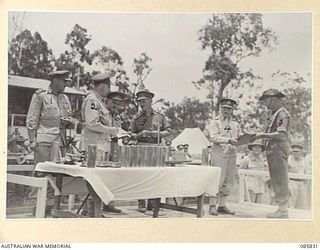 HERBERTON, QLD. 1945-01-19. LIEUTENANT T HULSE, 2 BEACH GROUP, (5), RECEIVES THE PRIZE WON BY HIS UNIT IN THE PLATOON DRILL EVENT, FROM LIEUTENANT GENERAL SIR LESLIE J MORSHEAD, GENERAL OFFICER ..