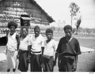 PA PA PAPUA. 1943-12-02. COUNSELLORS AND VILLAGE CONSTABLE OUTSIDE THE POLICE POST AFTER A MORNING COURT SESSION. THEY ARE LEFT TO RIGHT: KAIRI-WAROKA, BOERA VILLAGE COUNSELLOR; MAVARA-GOROGO, PA ..