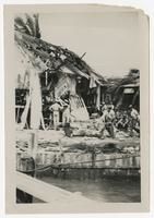 Litter Bearers in Front of Destroyed Motor Torpedo Squadron 3 Warehouse