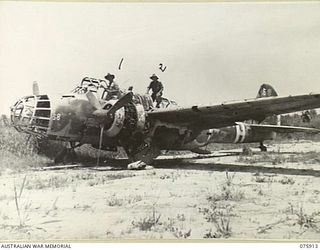 HANSA BAY, NEW GUINEA. 1944-09-06. QX40879 MAJOR R. WEPPNER, 25TH INFANTRY BATTALION (1) AND PRIVATE MORGAN (2) EXAMINING A WRECKED JAPANESE TWIN ENGINED BOMBER ABANDONED ON THE AWAR AIRSTRIP