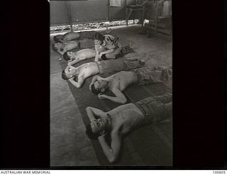 Lae, New Guinea. 1944-08-02. Lieutenant W. D. Nicholas, Physiotherapist, instructing scrub typhus patients in back strengthening exercises at 2/7th Australian General Hospital