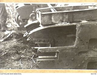 SCARLET BEACH AREA, NEW GUINEA. 1943-12-21. DAMAGED NEAR SIDE IDLER AND SPONSON CUT AWAY ON A MATILDA TANK AT THE 1ST AUSTRALIAN TANK BATTALION GROUP WORKSHOP, AUSTRALIAN ELECTRICAL AND MECHANICAL ..