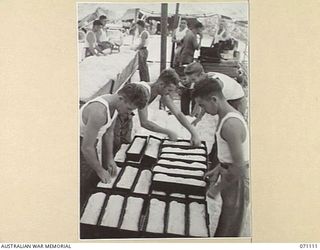 KILIGIA, NEW GUINEA. 1944-03-14. BAKERS OF THE 8TH FIELD BAKERY PLATOON, WITH BREAD IN THE MAKING. THE BREAD IS AT "PANS DOUGH" STAGE AND READY FOR THE OVEN