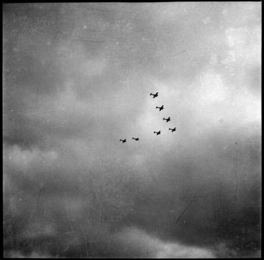 Seven aeroplanes flying in a "V" formation, Rabaul, New Guinea, 1937 / Sarah Chinnery