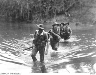 Forward scouts of the 35th Infantry Battalion cross the river during the unit drive up the coast towards Wewak