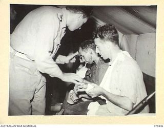 KALAI PLANTATION, HENRY REID BAY, NEW BRITAIN. 1945-03-05. WALKING CASUALTIES BEING EXAMINED ON ARRIVAL AT THE 6TH FIELD AMBULANCE