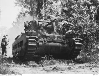 BOUGAINVILLE. 1945-04-17. A MATILDA TANK OF B SQUADRON 2/4 ARMOURED REGIMENT, WITH COVERING INFANTRY (SHOWN LIEUTENANT F.R. FOX) MOVING ALONG A TRACK IN THE HATAI JUNCTION SECTOR