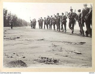 JABA RIVER AREA, BOUGAINVILLE, SOLOMON ISLANDS. 1944-12-18. B COMPANY, 15 INFANTRY BATTALION TROOPS WITH FULL PACKS IN MOVEMENT SOUTH ALONG THE BEACH TO TAKE UP NEW POSITIONS SOUTH OF THE JABA ..