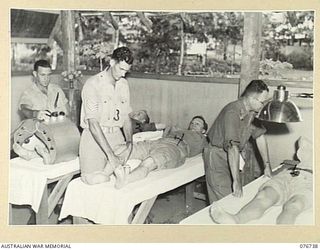 LAE, NEW GUINEA. 1944-11-09. WX35046 LIEUTENANT M.J. ROSEN (5), SERGEANT D.K. COOPER (3) AND CORPORAL W. TAYLOR (1), PHYSIOTHERAPISTS AT THE 112TH CONVALESCENT DEPOT, GIVING RADIANT HEAT TREATMENT ..