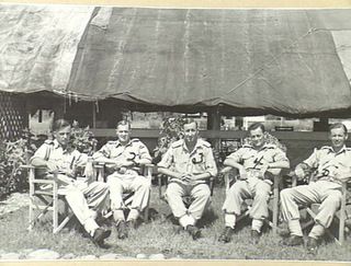 Outdoor group portrait of officers of the 18th Field Ambulance on the lawn in front of their mess. Identified from left to right: QX45903 Captain (Capt) Thomas Russell Neville; WX31556 Capt Harry ..