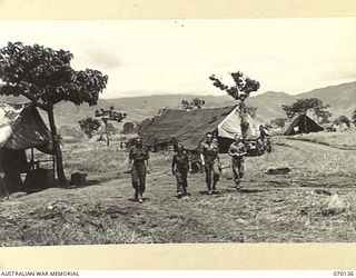 RAMU VALLEY, NEW GUINEA. 1944-02-04. W8605 PRIVATE A.X.G. NETTLETON (1); NX123634 PRIVATE L.N. HILL (2); NX163972 PRIVATE R.C. HIGGINS (3); VX136340 SERGEANT J.E. BOWLER (4), PICTURED AT A STORES ..