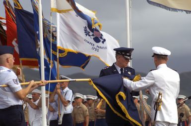 General Richard B. Myers, USAF, Chairman of the Joint Chiefs of STAFF, and Commander-in-CHIEF US Pacific Command Admiral Dennis C. Blair attach a streamer to the Pacific Commands flag during the Change of Command Ceremony for the Commander-in-CHIEF US Pacific Command at Marine Corps Base, Kaneohe Bay, Hawaii. During the Ceremony Admiral Dennis C. Blair relinquished his command to Admiral Thomas B. Fargo