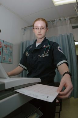 US Navy (USN) Navy Hospital Corpsman Third Class (HM3) Mary A. Rhudy reads an Electrocardiogram, while performing an Electrocardiograph (EKG), for a patient at Agana Naval Air Station (NAS), Guam